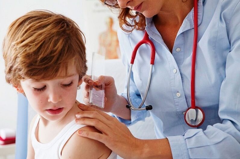 liječnik pregledava dijete s papilomom na tijelu